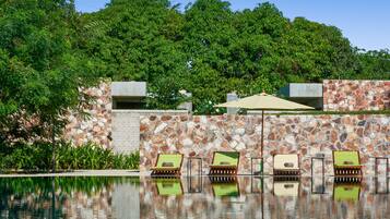 Uma área de piscina com espreguiçadeiras e um muro de pedra.