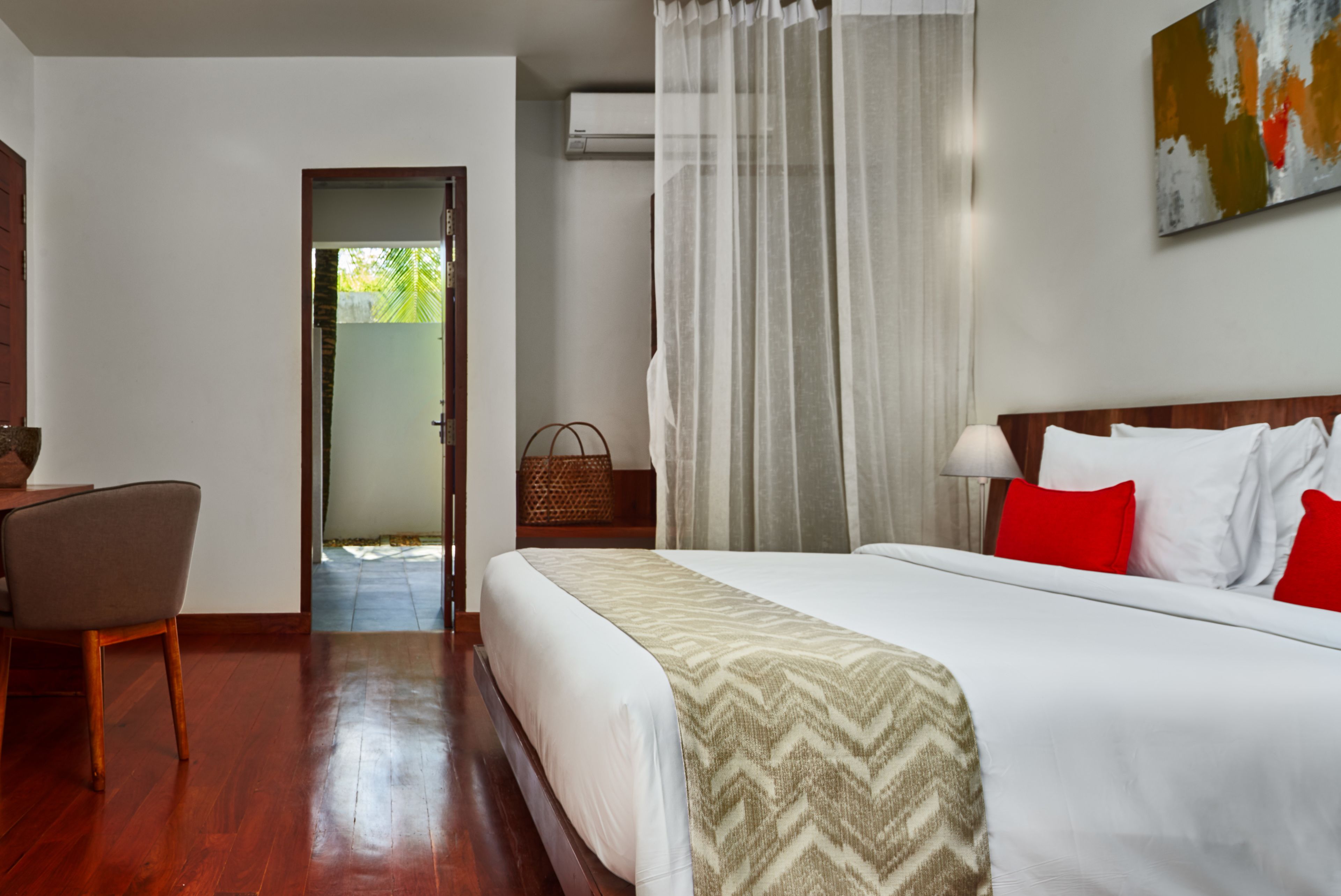 Ein Hotelzimmer mit Bett, Stuhl, Schreibtisch und Klimaanlage.