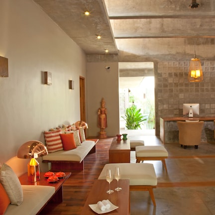A spacious lobby with a reception desk, seating area, and a statue.