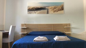 Un dormitorio con cama, escritorio y silla.