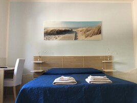 Un dormitorio con cama, escritorio y silla.