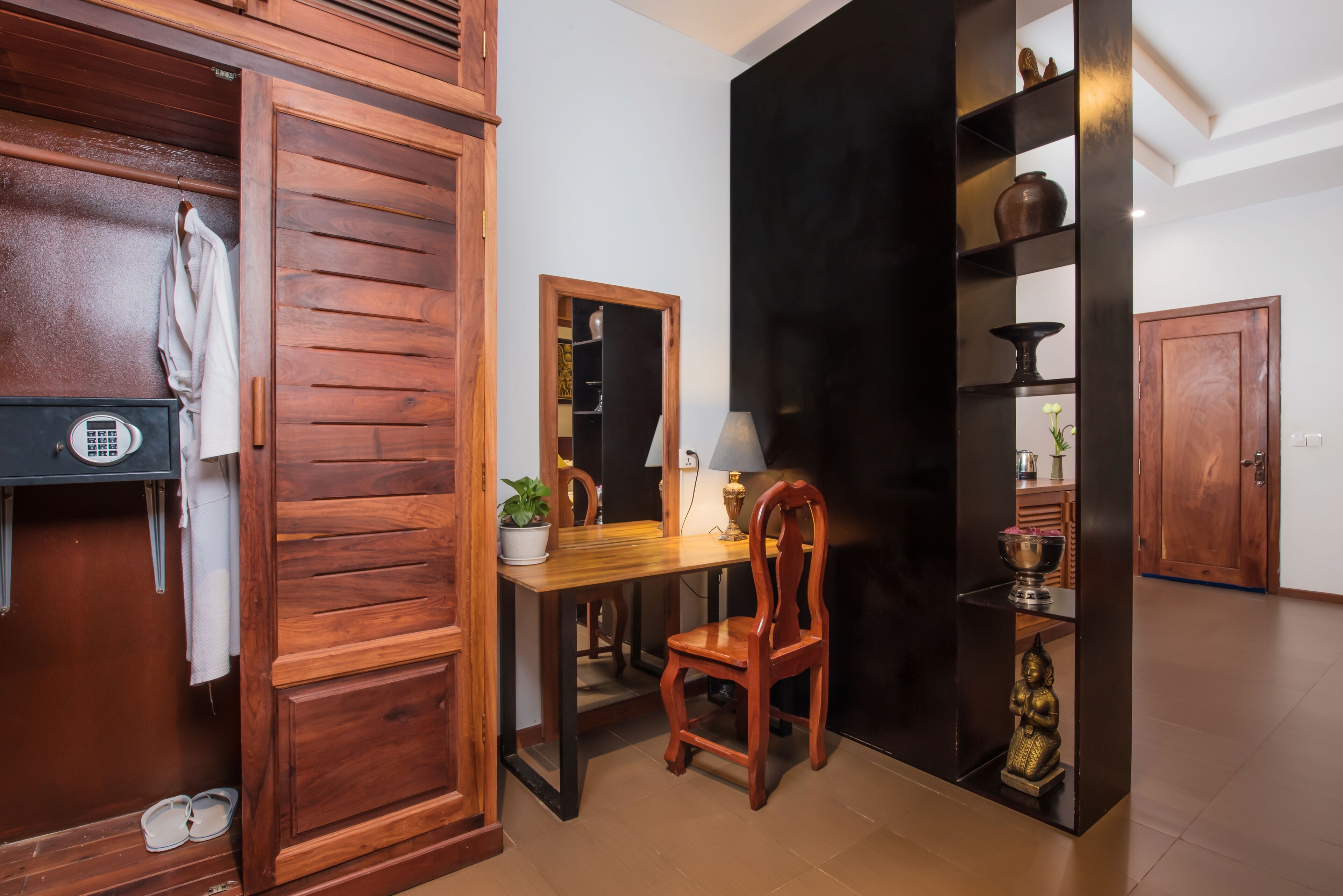 A wooden room with a desk, chair, and a shelf with decorative items.