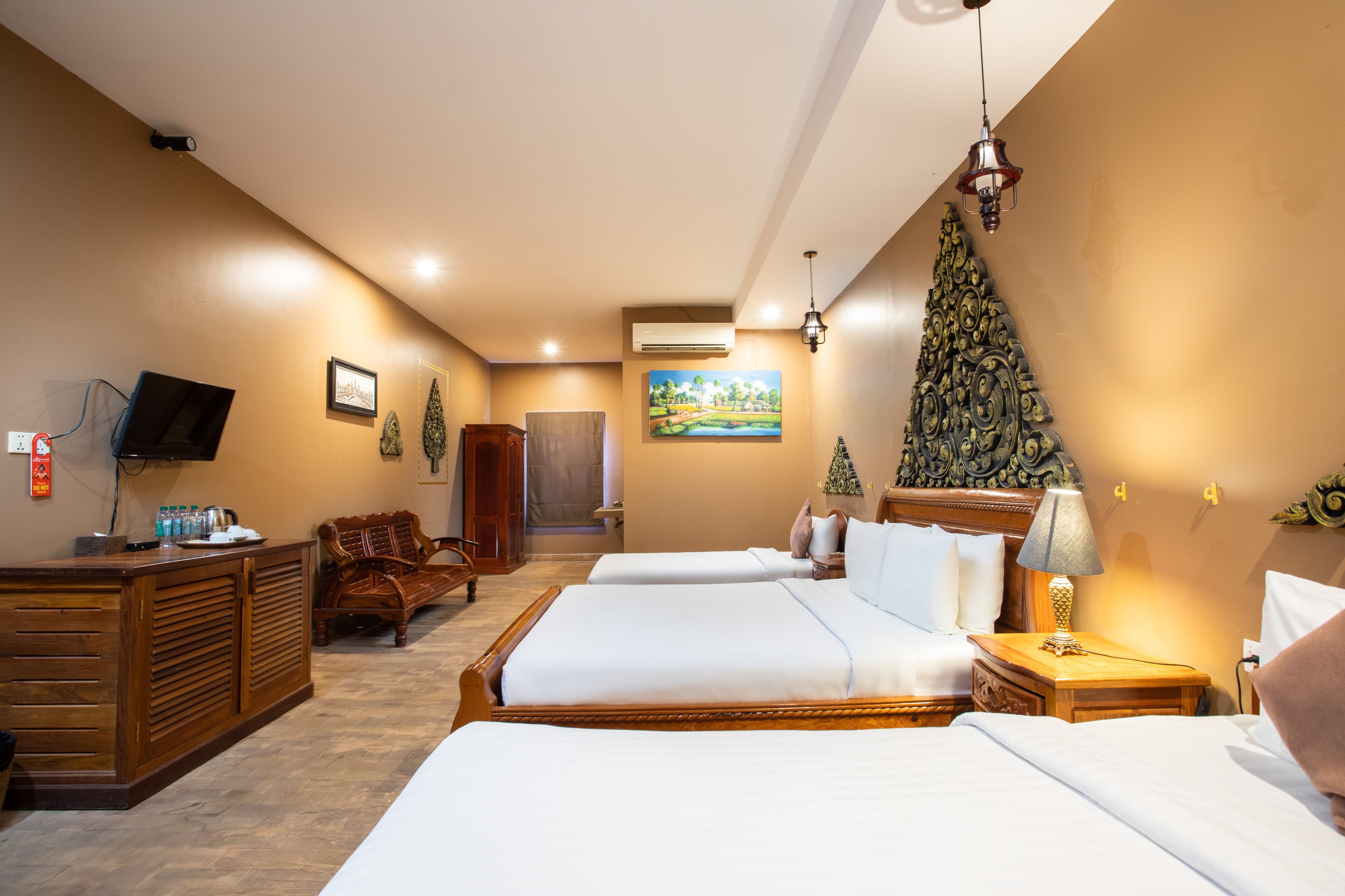Ein Hotelzimmer mit zwei Betten, einem Holztisch, einem Fernseher und einem Weihnachtsbaum.
