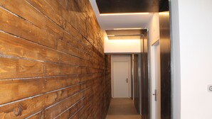 A hallway with wooden paneling, a door, and a light fixture. - B&B Girovagando (Rome)