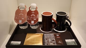 A tray with two water bottles, a coffee mug, and two coffee packets.