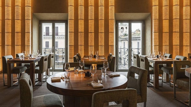 A restaurant with round tables, chairs, and tall, woven light fixtures. - Fendi Private Suites (Rome)
