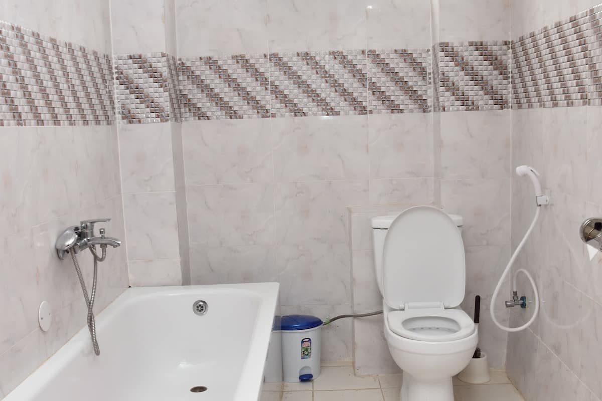 A bathroom with a bathtub, toilet, and shower.