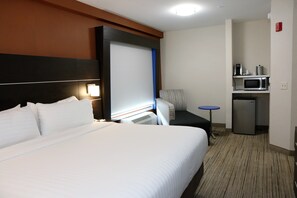 A hotel room with a large bed, a desk with a chair, a microwave, and a small refrigerator. - Holiday Inn Express & Suites Alabaster by IHG (Alabaster)