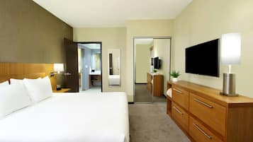 Una habitación de hotel con una cama grande, un aparador de madera, un televisor de pantalla plana y un espejo.