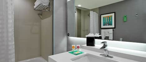 A modern bathroom with a bathtub, a sink with a mirror, and a shower area.