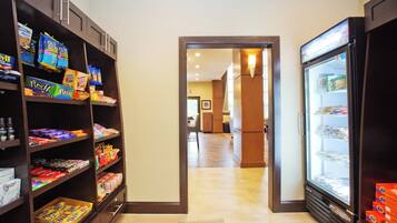 A hallway with snack shelves on both sides and a refrigerator on the right.