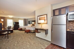 A hotel room with a bed, desk, chair, and kitchenette including a refrigerator and microwave. - Staybridge Suites Austin South Interstate Hwy 35 by IHG (Austin)
