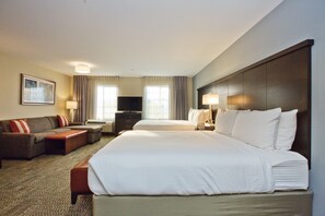 Een hotelkamer met een groot bed, een bank, een bureau en een televisie.