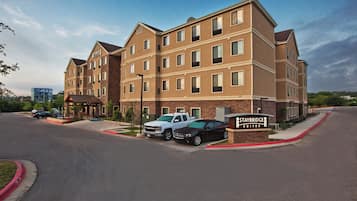 A multi-story hotel with a brick facade, a covered entrance, and a sign indicating Staybridge Suites.