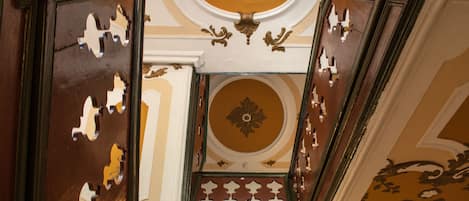 A staircase with ornate moldings and a decorative ceiling.