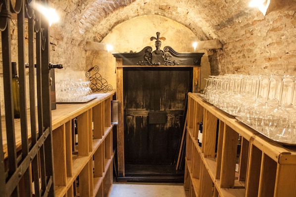 A wine cellar with wooden shelves and a vaulted ceiling. - Angelo d'Oro Heritage Hotel (Rovinj)