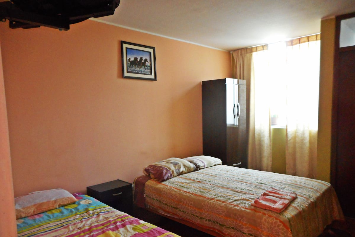 Una habitación con dos camas, un armario y un cuadro en la pared.