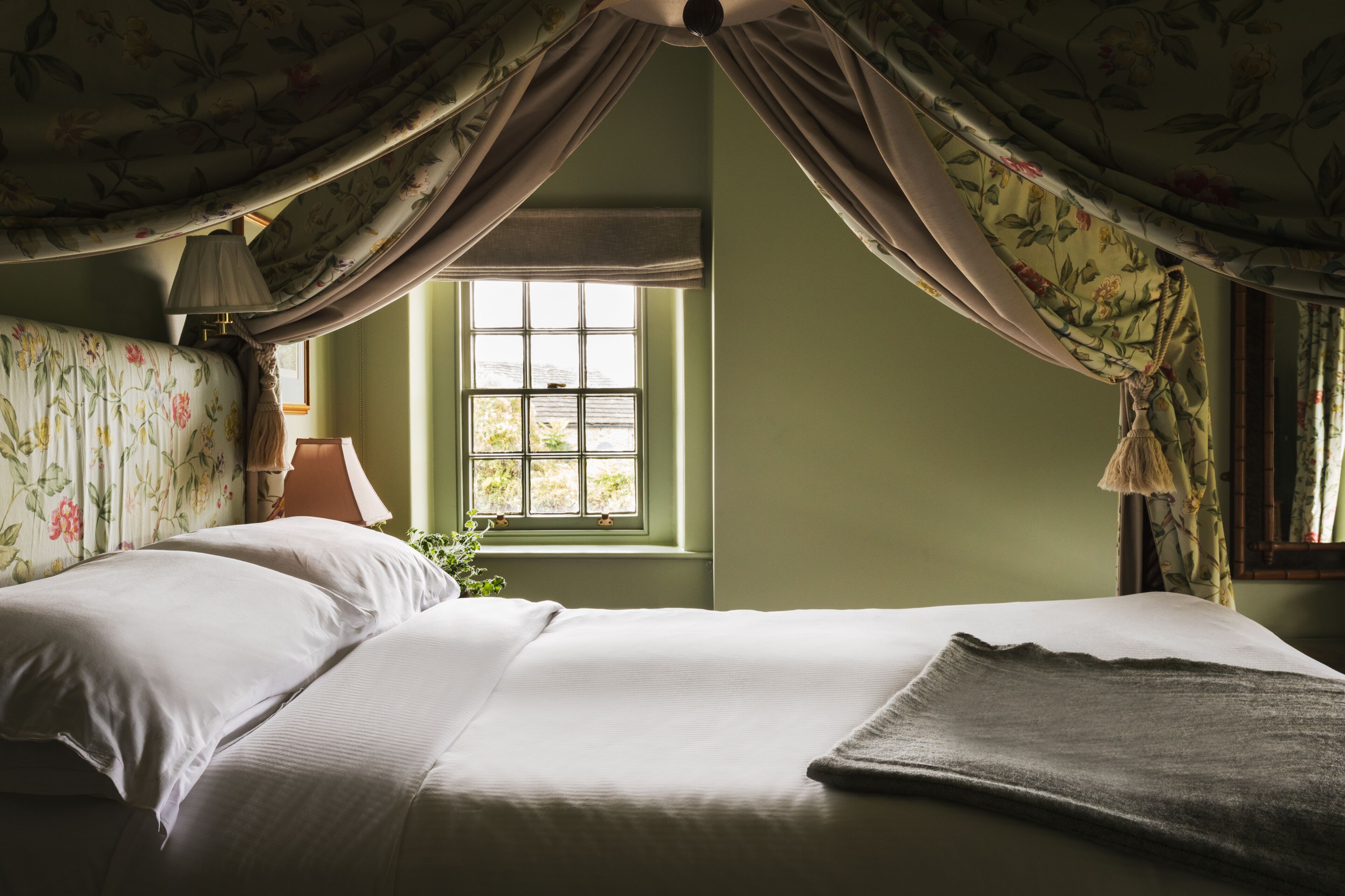 A room with a bed, a window, and curtains.