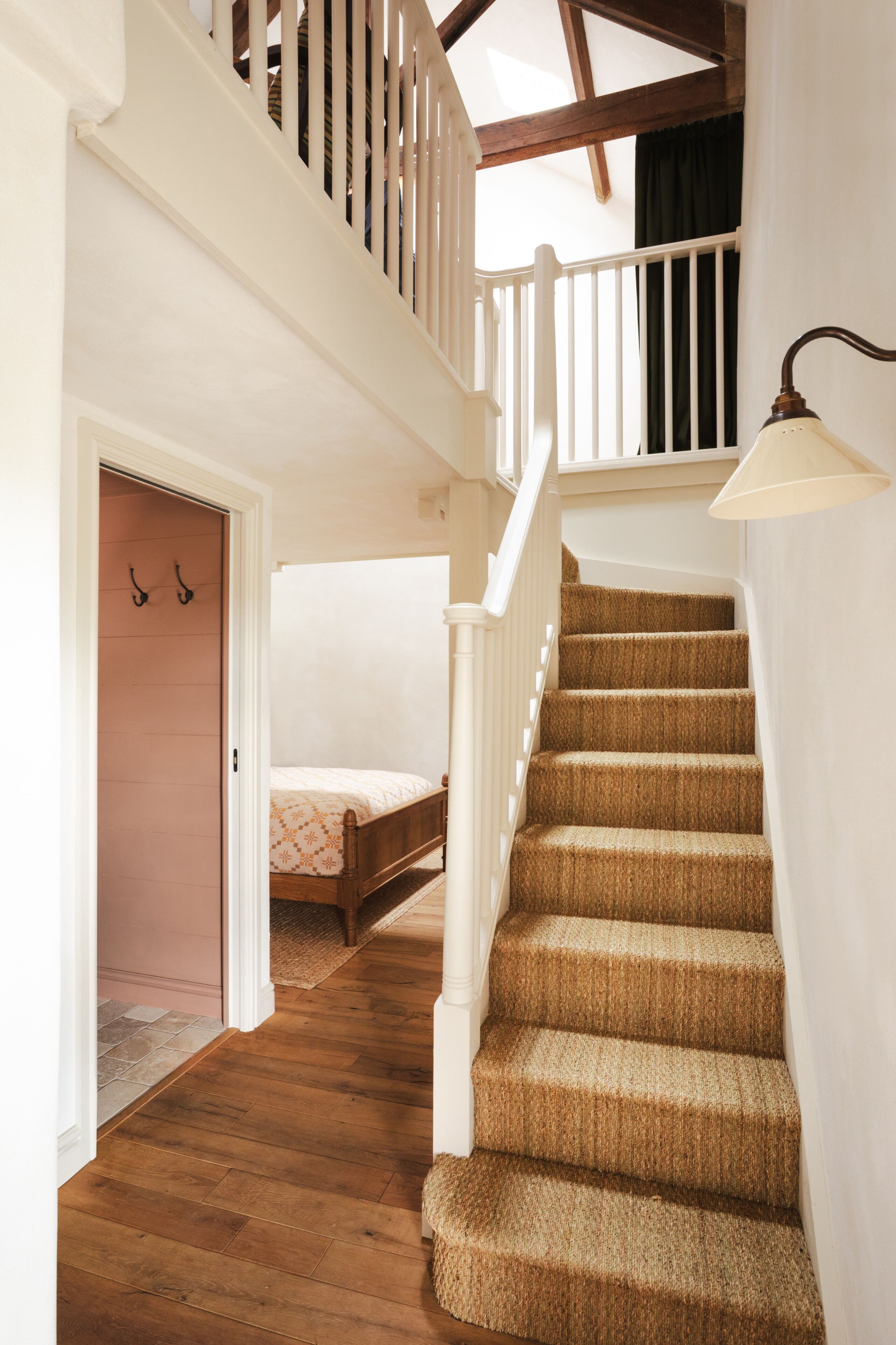 A staircase with wooden steps and white railings leading to a second floor.
