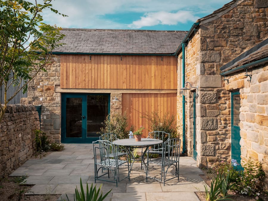 A stone building with a wooden door and a stone wall.