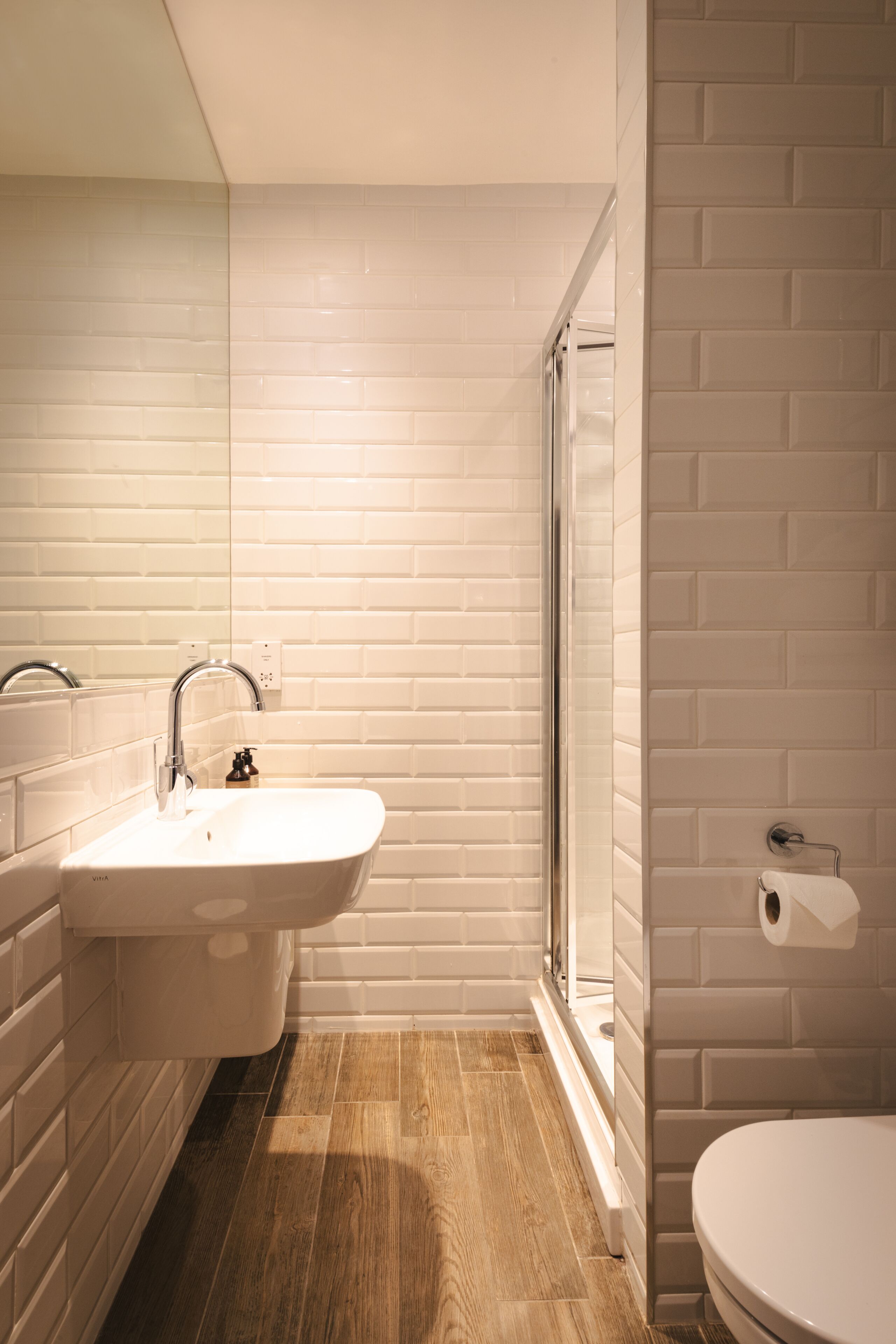 A bathroom with a white sink, a mirror, and a toilet.