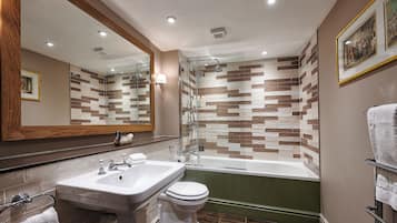 Un baño con bañera, lavamanos e inodoro.