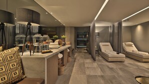 Un moderno espacio de spa con una camilla de masaje, un mostrador de recepción y un espejo.
