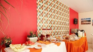 Ein reichhaltiges Buffet mit verschiedenen Speisen und einer Wand mit Muster im Hintergrund.