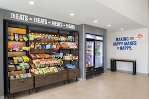 A snack display with a variety of packaged foods and a refrigerated section labeled 'SNACKS.' - Hampton Inn & Suites by Hilton San Diego SeaWorld Near Old Town (San Diego)