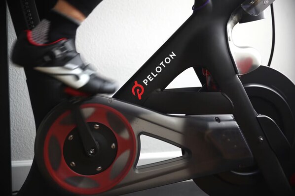Una bicicleta estática con el nombre de marca "PELOTON" en el cuadro.