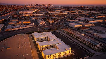 An aerial view of a cityscape at dusk with a prominent building complex in the foreground.