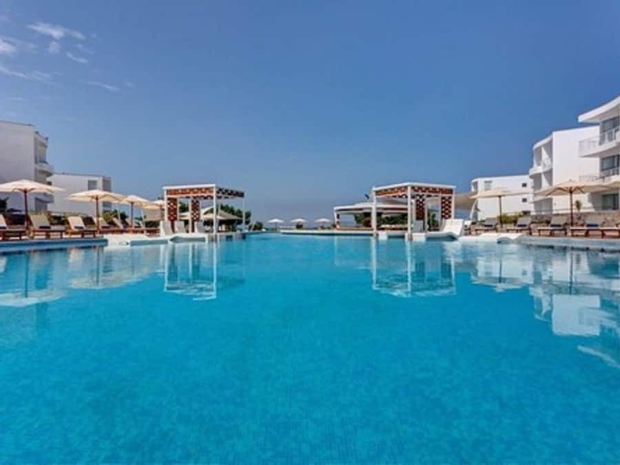 Una piscina al aire libre, sombrillas, tumbonas