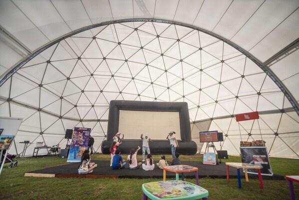 Una carpa grande con un escenario y zona de asientos para un evento.