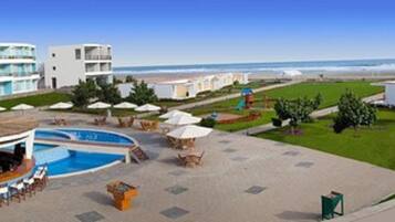 Un resort con piscina, zona de estar al aire libre y vistas a la playa.