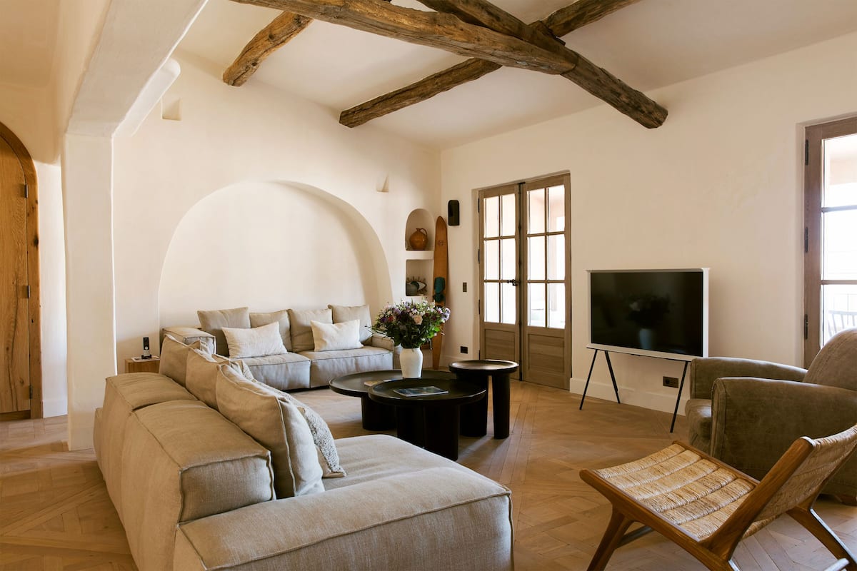 Una sala moderna con sofá, mesa de centro y televisor.