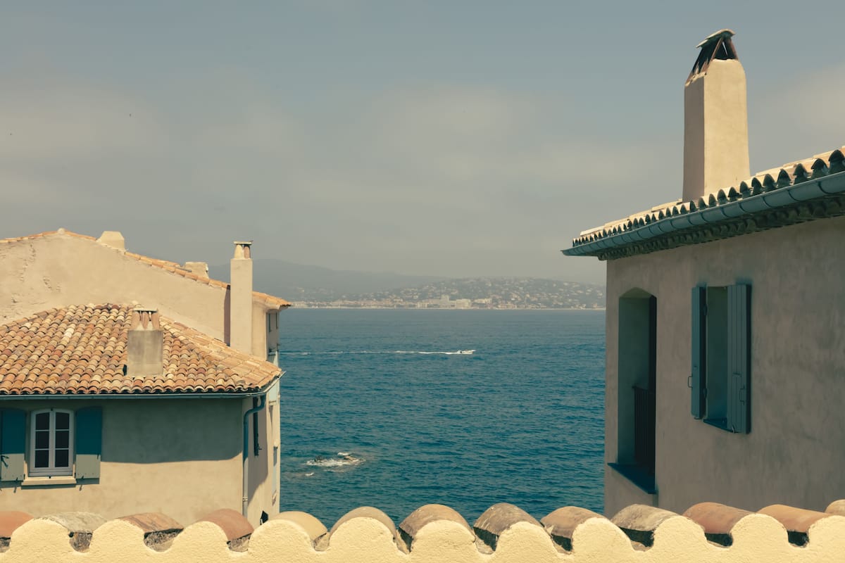 Un edificio costero con techo de tejas y vista al mar.