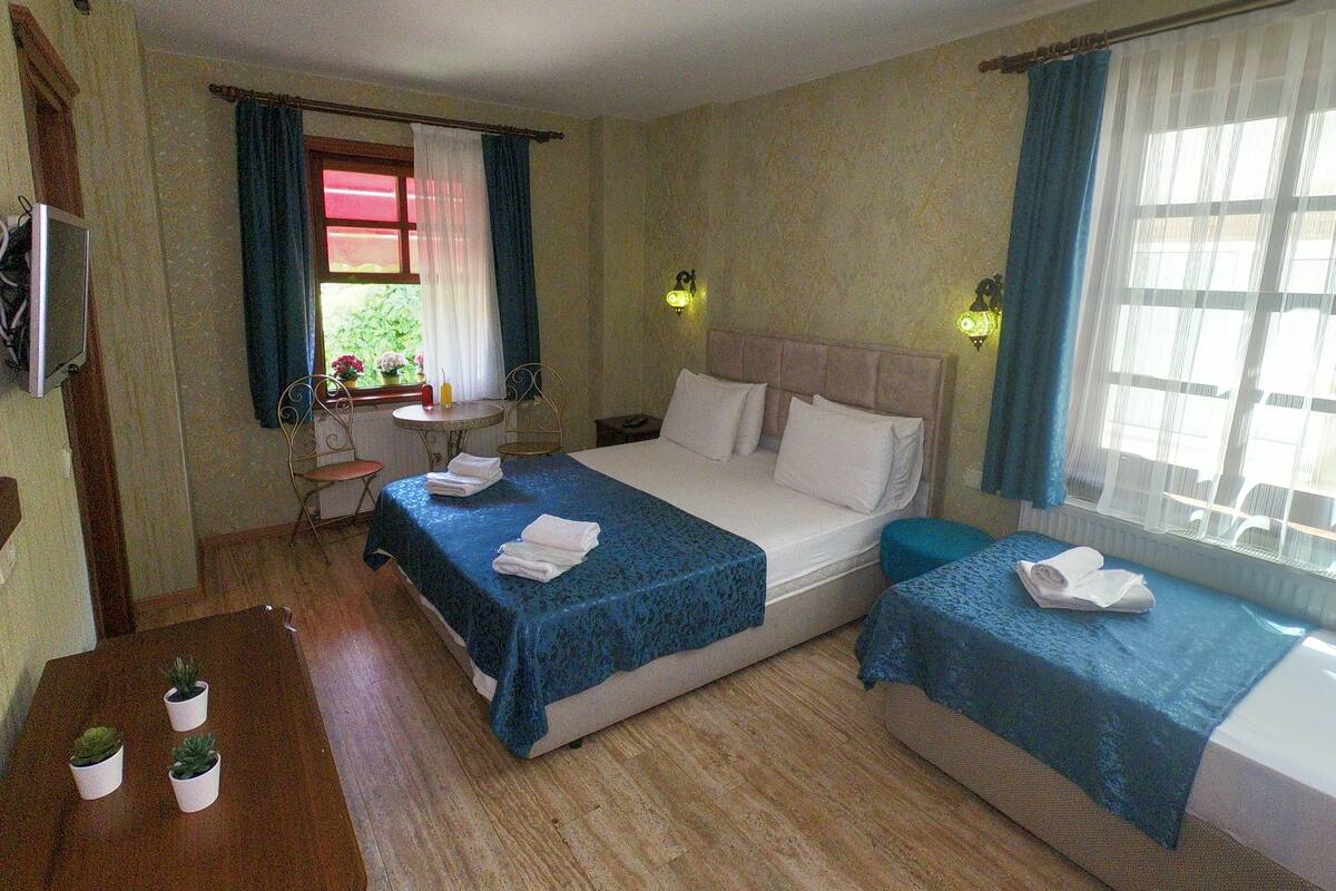 Driepersoonskamer | Luxe beddengoed, een minibar, een bureau, geluiddichte muren