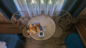 A dining table with a menu, a cup, and a chair. - Doruk Hotel (Ayvalik)