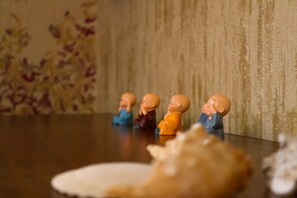Une table sur laquelle sont disposées quatre petites figurines dans différentes poses.