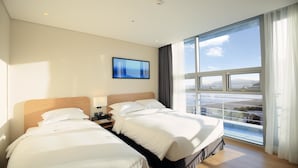 A hotel room with two beds, a large window with a view, and a flat-screen TV on the wall. - Best Western Haeundae Hotel (Busan)
