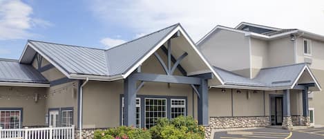 A building with a modern architectural design, featuring a prominent gabled roof and a stone foundation.