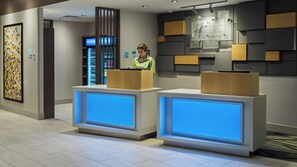 A reception desk with a digital display, a vending machine, and a wall-mounted sign. - Holiday Inn Express & Suites Medina by IHG (Medina)