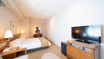 A hotel room with a bed, bedside table, lamp, TV, and a small cabinet.
