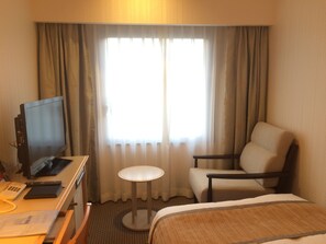 A hotel room with a bed, a desk with a computer, a chair, and a small table. - Hotel Terrace The Square Hitachi (Hitachi)