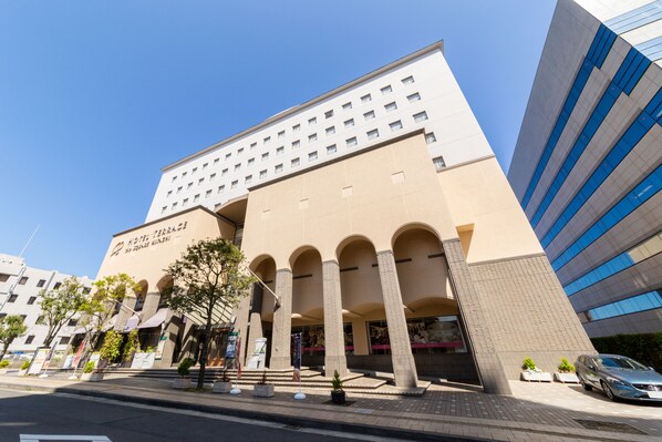 A modern hotel with a beige facade, multiple floors, and a prominent entrance with columns. - Hotel Terrace The Square Hitachi (Hitachi)