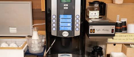 En kaffemaskine med digitalt display, flere knapper og en vanddispenser.