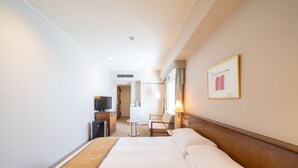 A hotel room with a large bed, a television, a desk, and a chair. - Hotel Terrace The Square Hitachi (Hitachi)