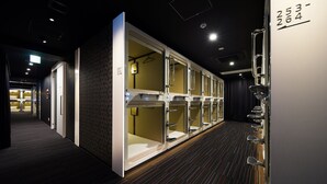 A hotel corridor with multiple rooms, each with a door and a small window. - Tokyo Ariake Bay Hotel (Tokyo)