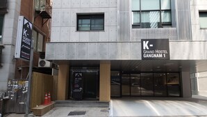 Un edificio moderno con un cartel que dice 'K-Guest House Gangnam 1'.