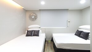 Una habitación de hotel moderna con dos camas, un reloj de pared y un ventanal con vistas.